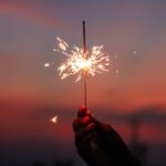 Leveraging Holidays for Luxury Real Estate Networking. Person holding sparkler.