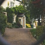 Building Relationships with Gatekeepers in Luxury Real Estate. Blurred gate with a luxury home entrance behind.